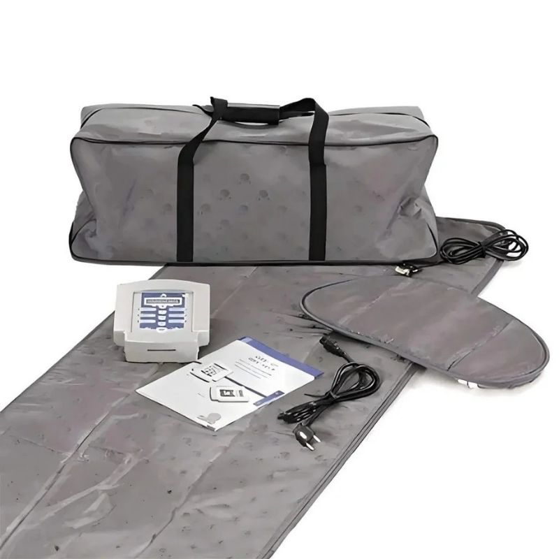 Gray heating pad with digital controller, power cord, and user manual on a white background