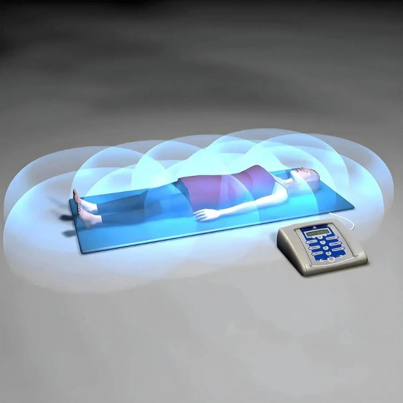 Digital display showing a person lying on a bed with a control panel next to it.