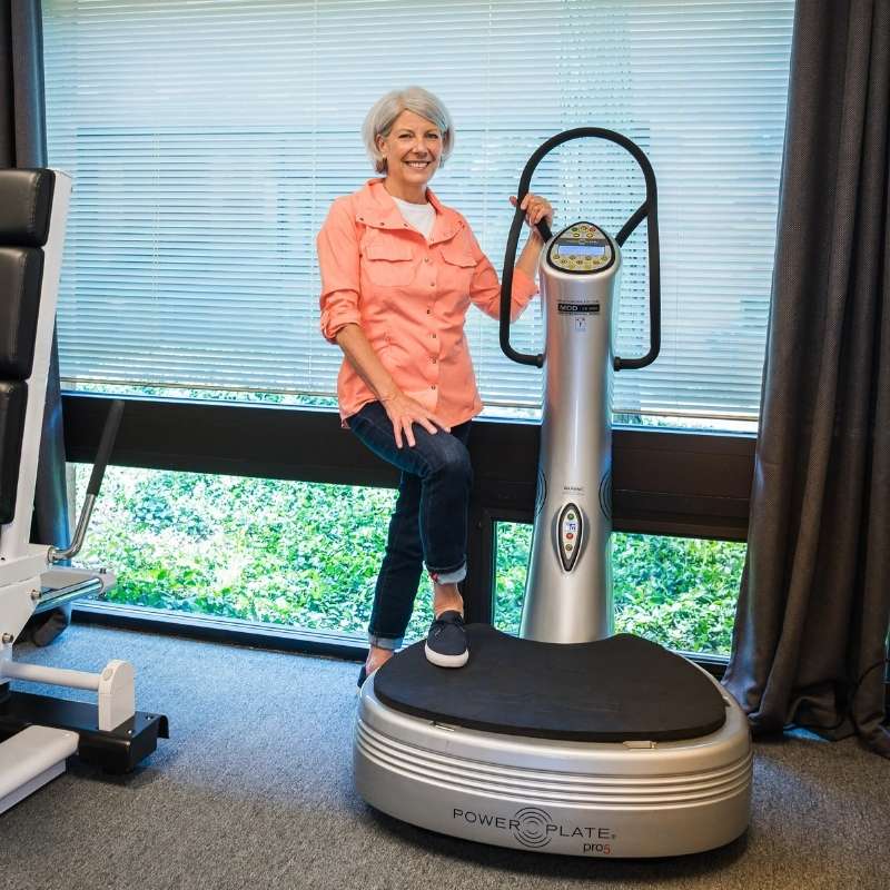 Woman using a Power Plate machine in a home setting