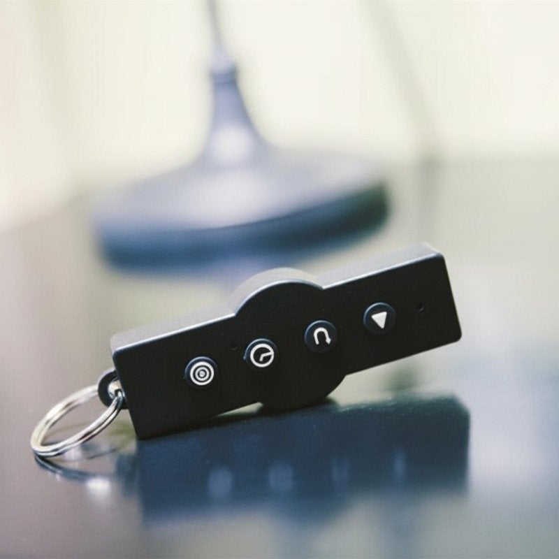Black keychain device with buttons on a reflective surface
