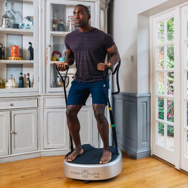 Man using a Power Plate machine in a home setting